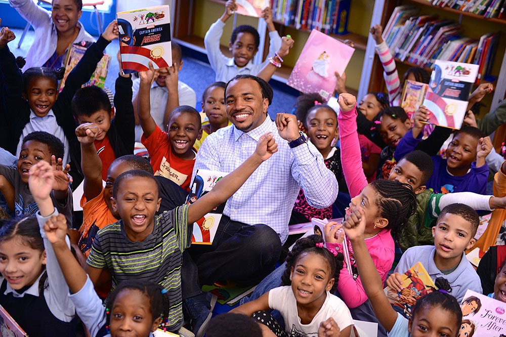 Children in a school library cheering and holding books